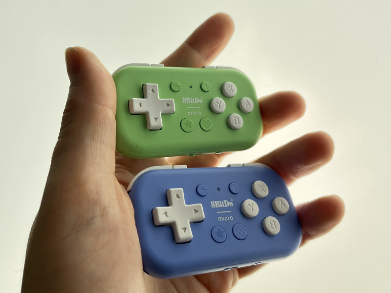 Two 8BitDo Micro controllers in hand